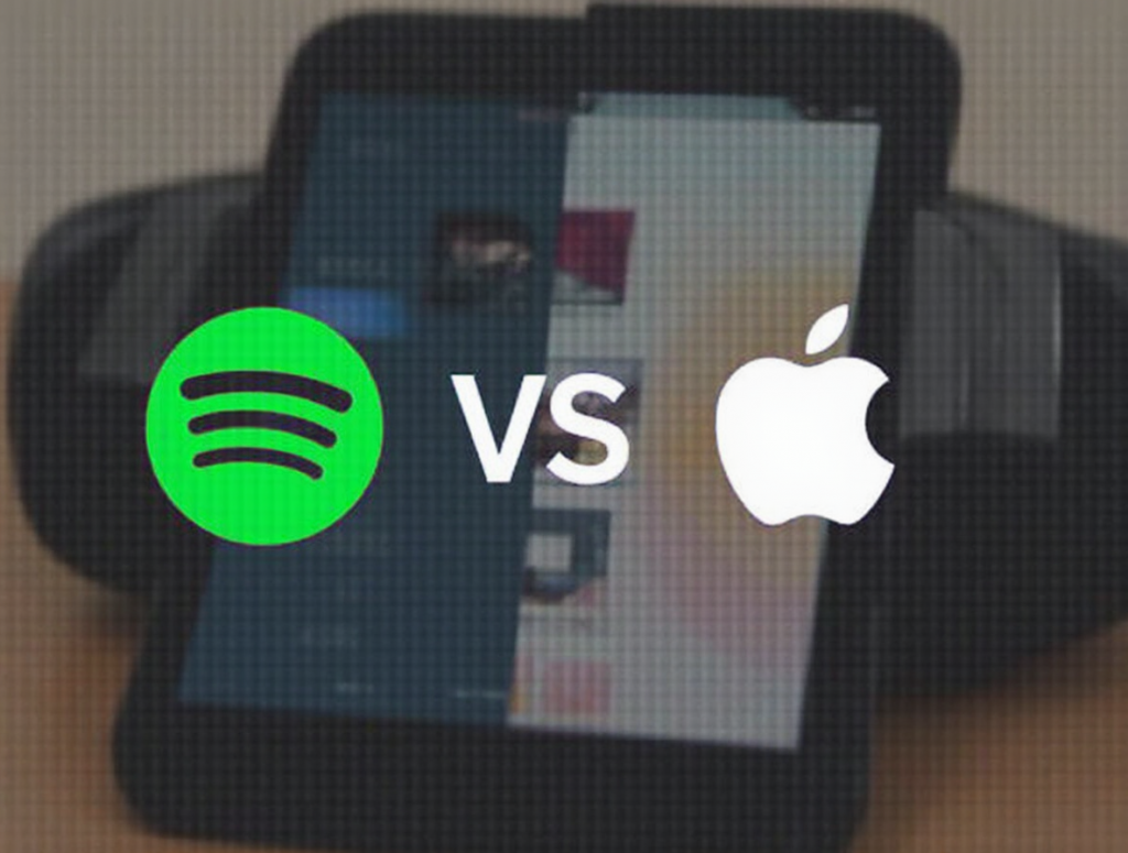 A side-by-side comparison of Spotify and Apple Music with their logos and a ‘vs’ sign in the center. A smartphone screen displays both streaming apps, highlighting their interface differences in a competitive showdown.
